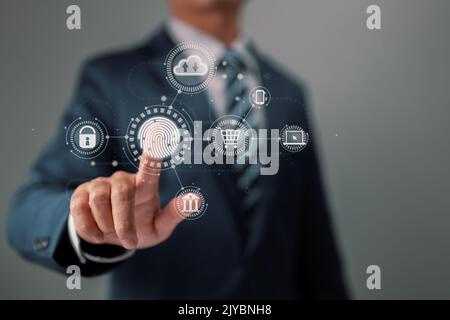 On a virtual screen displaying online transactions, a businessman's fingerprint offers a secure gateway for online shopping, banking, and cloud comput Stock Photo