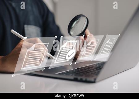 hand using a laptop computer with a virtual screen and document for paperless quality assurance and ERP management concept for online approval. Stock Photo