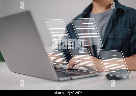 Laptop computer with electronic document icons, E-document management, an online documentation database, and the notion of a paperless workplace in mi Stock Photo
