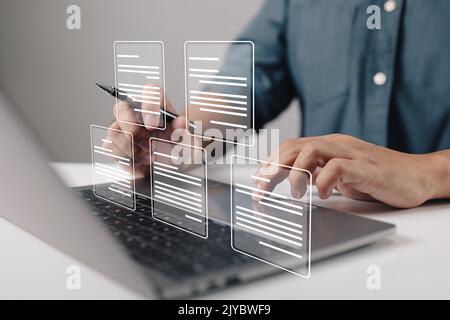 A businessman using a laptop computer with electronic document icons, E-document management, an online documentation database, and the concept of a pa Stock Photo