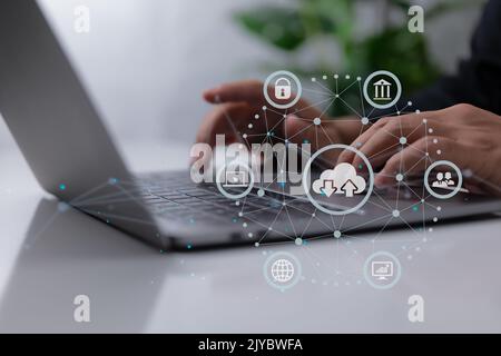 Man uses a laptop with a cloud computing schematic. Cloud computing is a type of technology that allows you to store Storage of information. Concept o Stock Photo