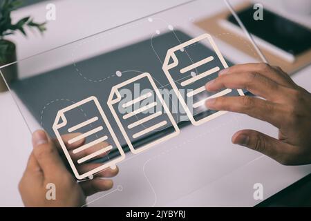 A paperless office is a concept based on electronic document management and a web-based documentation database. Working on a tablet computer, a busine Stock Photo