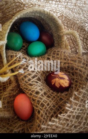 The holiday of Easter, hen eggs painted in the traditional colors, kulich, festive cake, church candles. Stock Photo