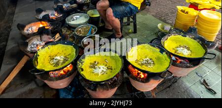 Vietnam food, banh xeo or vietnamese pancakes being fried under hot coals, they are made with rice flour and filled with a soya bean sprouts, is popul Stock Photo