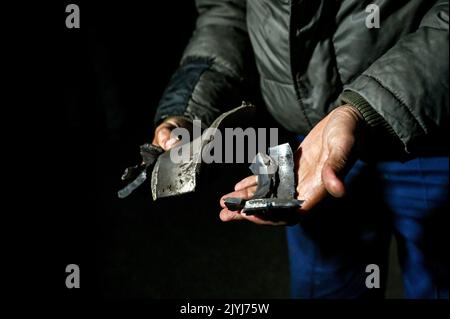 MALA TOKMACHKA, UKRAINE - SEPTEMBER 7, 2022 - Local resident and eyewitness Dmytro shows a fragment of a rocket to the press after the shelling of Rus Stock Photo