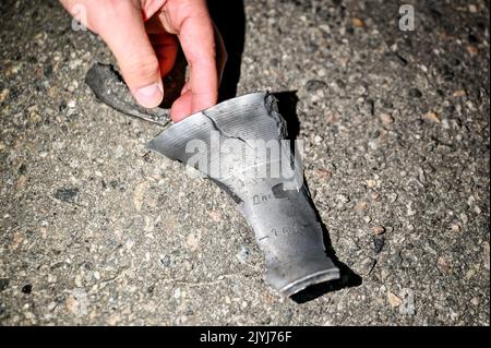 MALA TOKMACHKA, UKRAINE - SEPTEMBER 7, 2022 - Local resident and eyewitness Dmytro shows a fragment of a rocket to the press after the shelling of Rus Stock Photo