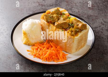 Traditional African bread based street food called Bunny Chow closeup on plate on the table. Horizontal Stock Photo