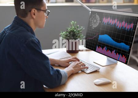 Millennial Businessman Analyzing Financial Statistics On Computer Screen While Working In Office Stock Photo