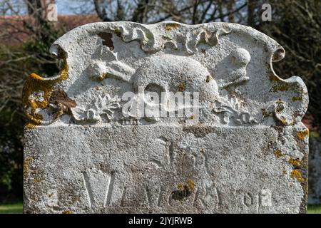 A gravestone with skull and crossbones in a church yard in Warbleton, East Sussex. Stock Photo