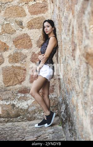 Portrait young attractive woman looking at the camera smiling standing over isolated stone background Stock Photo