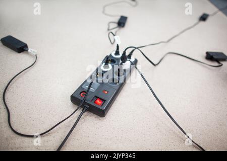 Extension cord electrical outlet which many devices Stock Photo