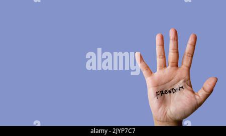 Word freedom written on hand isolated on blue background. copy space. banner. Stock Photo