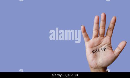 Word rise up written on hand isolated on blue background. copy space. banner. Stock Photo