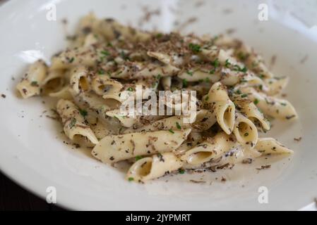Fresh ziti pasta in truffle mushroom sauce, served on a white plate Stock Photo