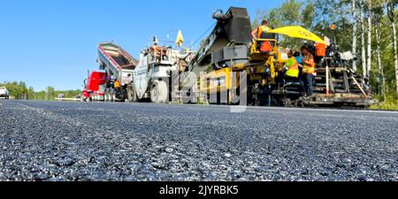 Rivière Héva, Québec, Canada, 2022-09-07, Asphalt in focus with paving machinery in background Stock Photo