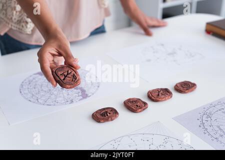 Constellation Runes partial view of oracle holding clay rune and constellations map Stock ...