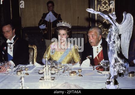 FILE 1983-05-25Britain's Queen Elizabeth II sits between the Swedish King Carl XVI Gustaf (L) and Price Bertil (R) at the dinner table during a royal gala dinner at the Royal Palace in Stockholm, Sweden on May 25, 1983. The British royal couple is in Sweden on a four-day official state visit May 25 to 28. Photo: Jan Collsioo / SCANPIX SWEDEN / Code: 1001 Stock Photo