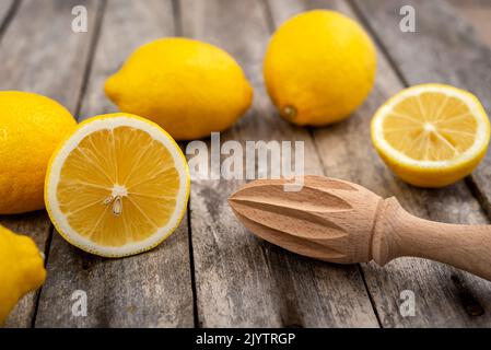 Fresh lemons and wooden juicer on rustic table. Selective focus. Stock Photo