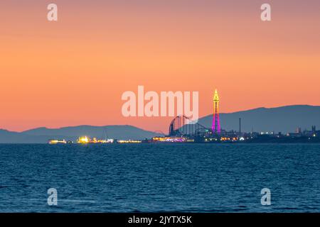 Blackpool attractions against a dusk sky with hills of Cumbria in the background. Blackpool Tower, The Big One, Central Pier. Fylde Coast. England, UK Stock Photo