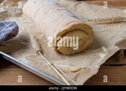 Swiss roll without filling on a baking sheet Stock Photo