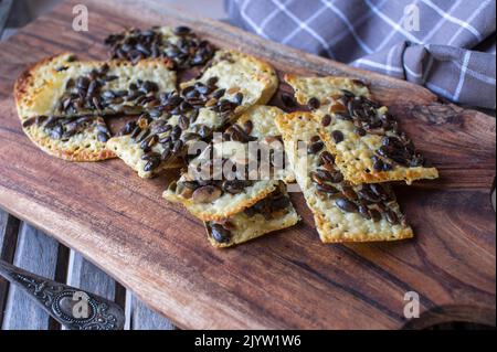 Low carb snack with homemade cheese cracker topped with pumpkin seeds Stock Photo