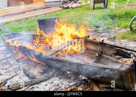 bonfire, an old wooden boat is burning in bonfire. burning of garbage Stock Photo