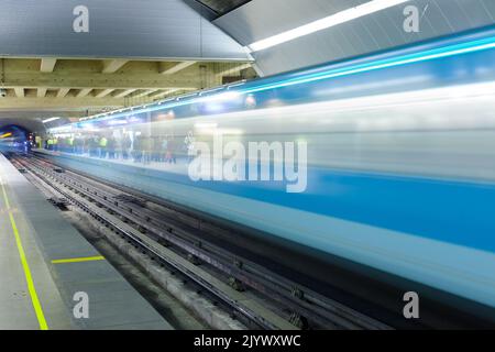 Santiago, Region Metropolitana, Chile - Motion blur of a subway train at Metro de Santiago with people waiting in the platform. Stock Photo