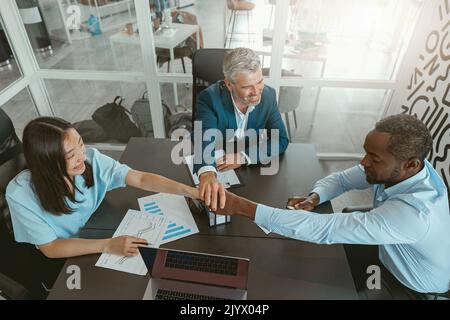 Top view of group multi ethnic coworkers stacked hands together as concept of corporate unity Stock Photo