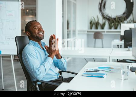 Handsome african businessman working computer while sitting in modern coworking Stock Photo