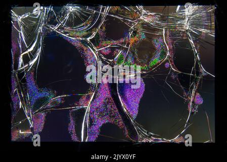 Broken and shattered LCD screen on the rear of a compact photographic camera. The screen shows some light despite the serious damage. (132) Stock Photo