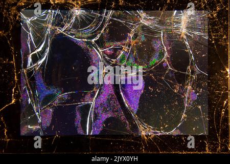 Broken and shattered LCD screen on the rear of a compact photographic camera. The screen shows some light despite the serious damage. (132) Stock Photo