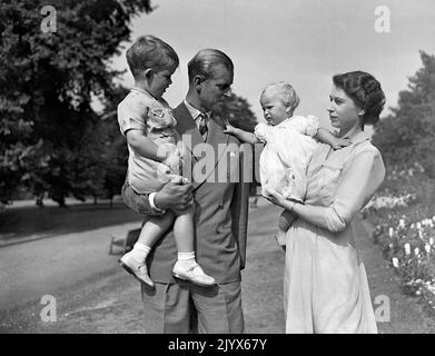 File photo dated 09/08/1951 of Princess Anne in the arms of Princess Elizabeth (later Queen Elizabeth II), with the Duke of Edinburgh, holding Prince Charles, in the grounds of Clarence House, London. The Queen died peacefully at Balmoral this afternoon, Buckingham Palace has announced. Issue date: Thursday September 8, 2022. Stock Photo