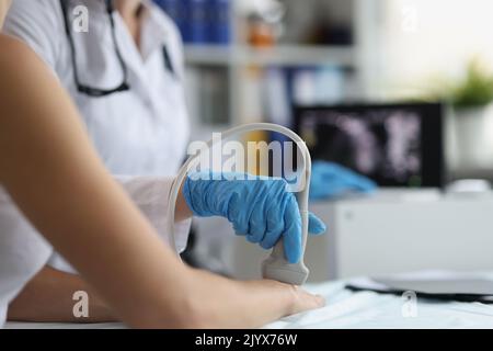 Doctor makes ultrasound of wrist in clinic closeup Stock Photo