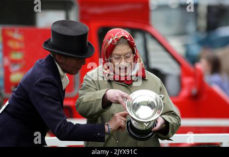 File photo dated 14/5/2010 of Queen Elizabeth II looks at the cup that her horse Stardust III, ridden by Katie Jerram (left), won in the Ladies Side-Saddle class at the Royal Windsor Horse show at Windsor Castle. In the 30 years up to 2017, the Queen won around £6.7 million in prize money from horse racing. Issue date: Thursday September 8, 2022. Stock Photo