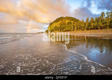 A rainbow in the sky above Tow Hill and Agate Beach, in Haisa Gwaii, British Columbia Stock Photo