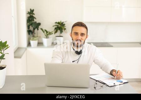 Dedicated entrepreneur sitting at office desk and reading an e-mail while working on a computer Stock Photo