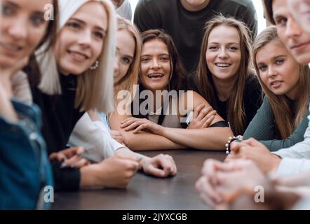 many diverse young people sitting at one table Stock Photo