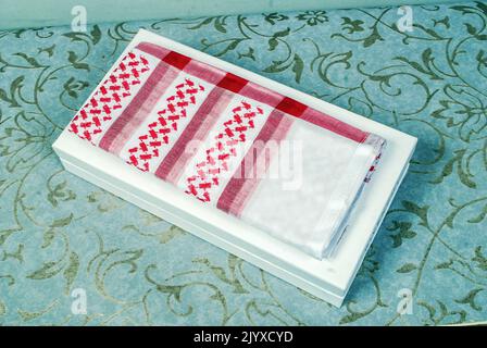 Arab Muslim men,s cultural head scarf named Shemagh ghutrah isolated red and white fabric clothing accessory middle eastern traditional dressing Stock Photo