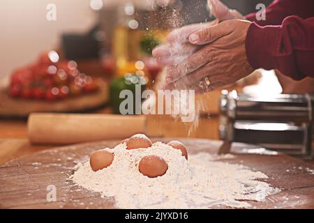 Pasta prep. a person preparing pasta dough in a kitchen. Stock Photo