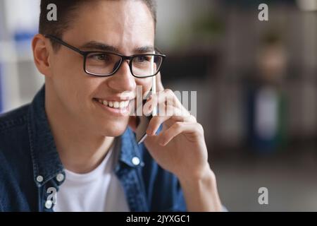 Close Up Of Millennial Handsome Man Wearing Eyeglasses Talking On Mobile Phone Stock Photo