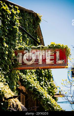 A rustic motel sign covered in ivy outside of downtown San Luis Obispo, California on a summer day. Stock Photo