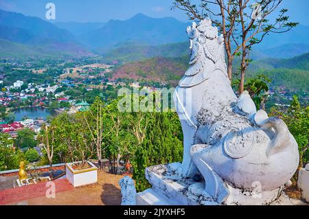 The statue of Singha (Chinthe) lion atop Doi Kong Mu Hill against the hazy mountain landscape, Mae Hong Son, Thailand Stock Photo