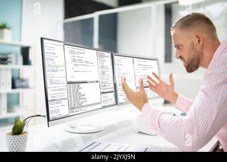 Confused Angry Programmer Using Computer In Programming Stock Photo