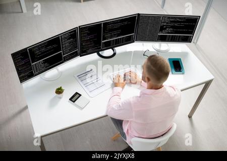 Computer Programmer Writing Program Code On Computer In Office Stock Photo