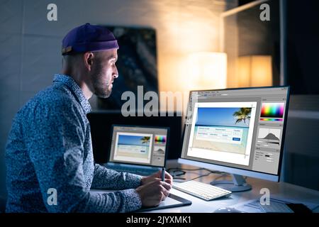 Graphic Designer Working Late At Night In Office Stock Photo