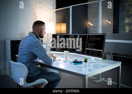 Computer Programmer Writing Program Code On Computer In Office Stock Photo