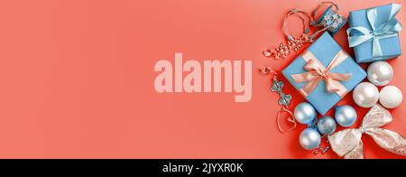 Gift boxes and Christmas decorations on a coral background. The concept of Christmas and New Year. Stock Photo