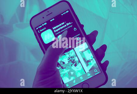 Metaverse Tech Lifestyle Concept - Close-up of a hand holding a mobile phone with metaverse experience app on screen display.