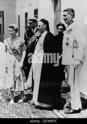 Her Majesty With The King Of Libya -- King Idris of Libya points our places of interest to the Queen and the Duke of Edinburgh form the balcony of the royal palace at Tobruk. The King later presented a number of gifts to her Majesty for members of her family. May 2, 1954. (Photo by Paul Popper, Paul Popper Ltd.). Stock Photo