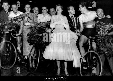 Australians win Six-Day Cycle Race: Unidentified; Russell Mockridge (on cycle); Marie Berlioz, Vice Queen of the Race; Unidentified; Reginald Arnold (on cycle); Unidentified; Jacqueline Joubert, Queen of the race; French boxing champion Charles Humez; Sydney Patterson (holding Winners' cup, on Bike); Unidentified. The Australian team after winning the six-day cycle race in Paris last night, March 9. They covered 4,132.5 kilometers at an average speed of 32.34 kilometers an hour (about 2,567.841 miles at an average speed of 20.085 miles an hour). They pulled up from 11th place in the last 24 ho Stock Photo